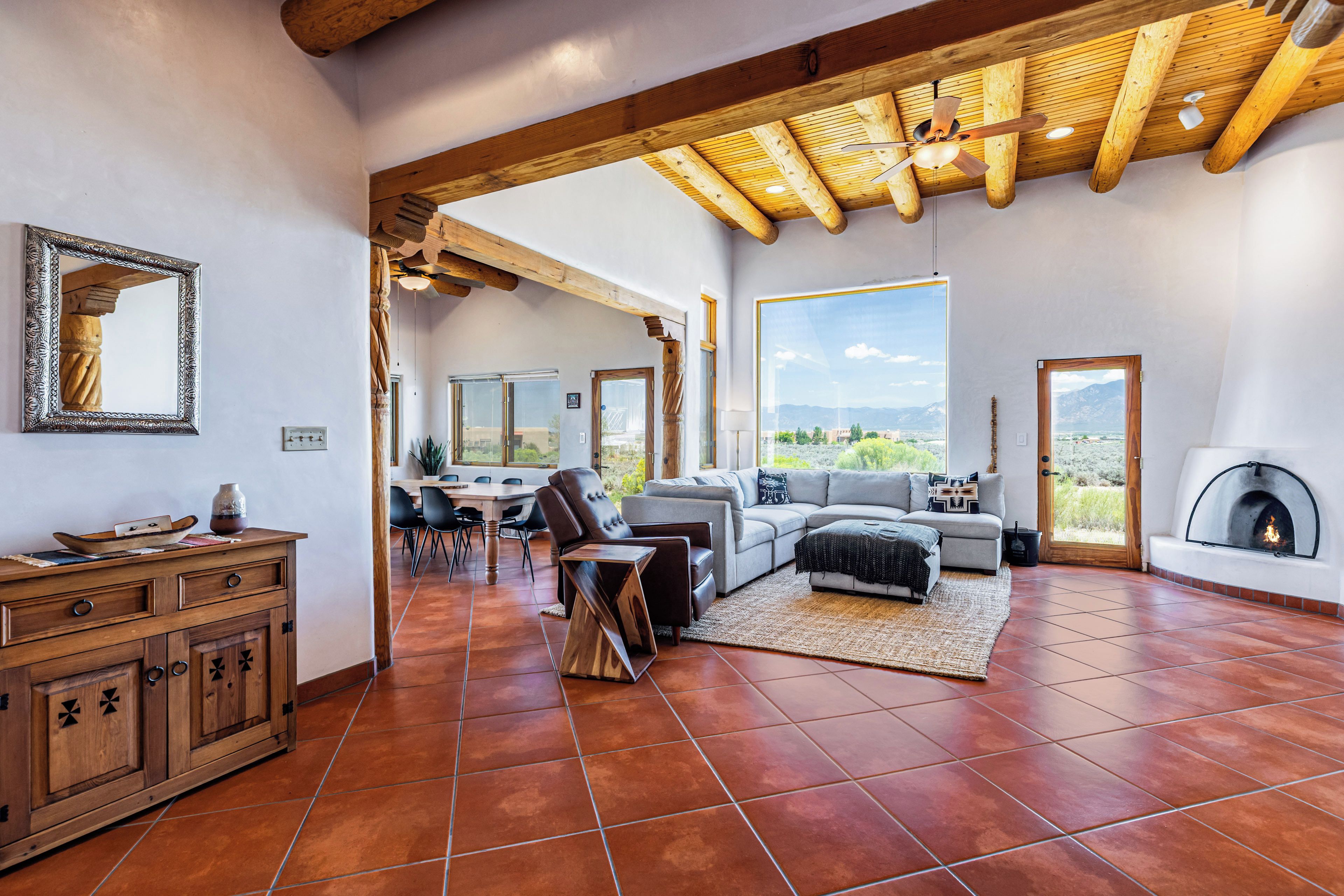 A spacious living area with a fireplace, a dining area, and a view of the outdoors.