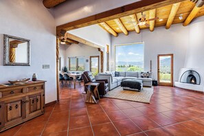 A spacious living area with a fireplace, a dining area, and a view of the outdoors.