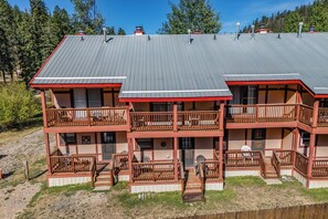 A two-story building with a flat roof, multiple balconies, and a wooden deck. - Tenderfoot Retreat - Creekside, Near Ski & Town (Red River)
