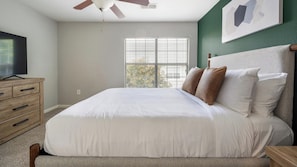 A bedroom with a bed, a dresser, a ceiling fan, a window with blinds, and a painting on the wall. - Landing | Stylish 1BD, Gym, Clubhouse (Murfreesboro)
