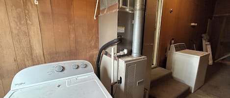 Et vaskerum med en vaskemaskine fra Whirlpool, en tørretumbler og en stablet vaske- og tørretumblenhed.