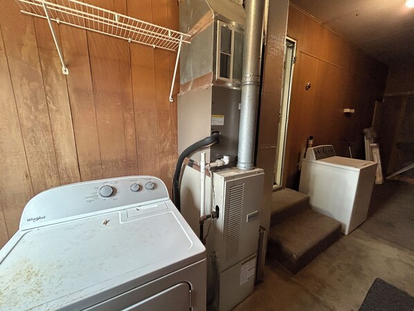 A laundry room with a Whirlpool washer, a dryer, and a stacked washer and dryer unit.