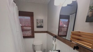 Ein kleines Badezimmer mit Toilette, Waschbecken und Spiegel.