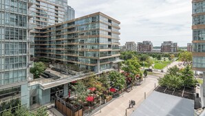 Un bâtiment moderne à plusieurs étages, doté de grandes fenêtres et d’une terrasse sur le toit.