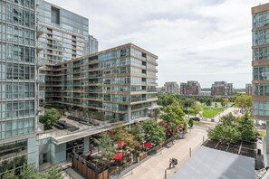 Ein modernes Gebäude mit mehreren Etagen, großen Fenstern und einer Dachterrasse.