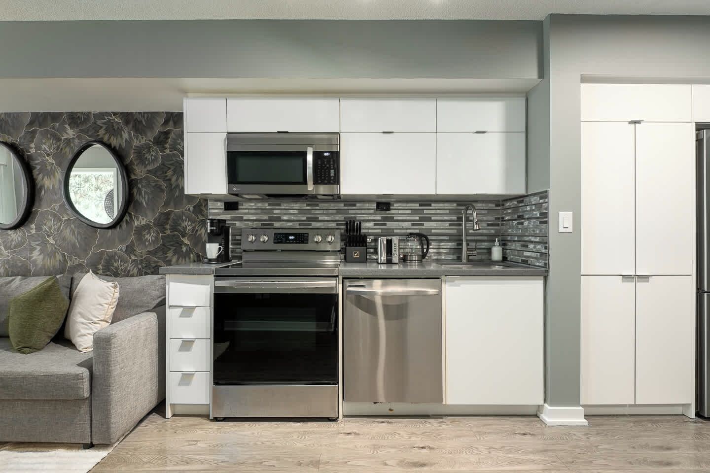 A modern kitchen with stainless steel appliances, a built-in oven, and a dishwasher.