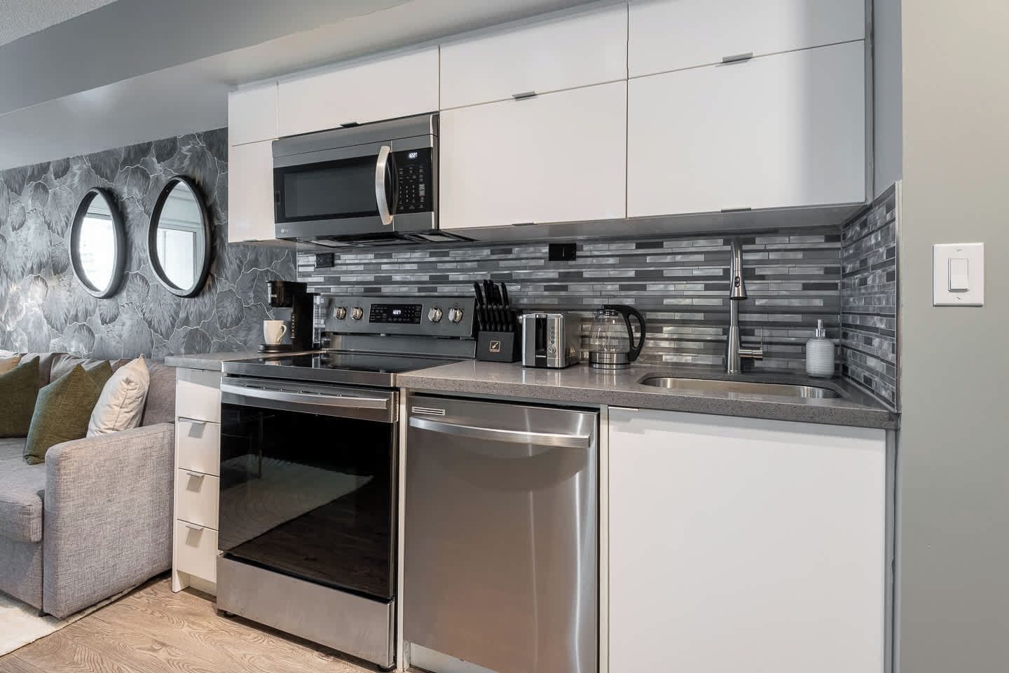 A modern kitchen with stainless steel appliances, a built-in oven, and a microwave.