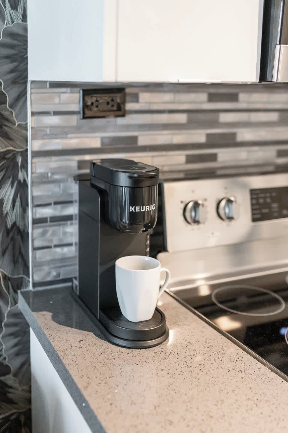 A Keurig coffee maker on a countertop with a white mug.