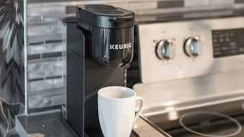 A Keurig coffee maker on a countertop with a white mug.