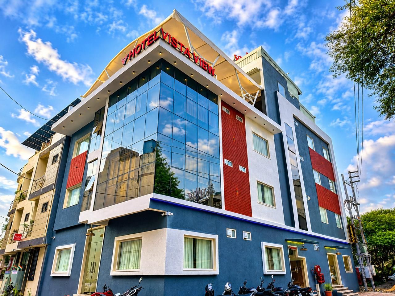 A multi-story hotel with a modern design, featuring large glass windows and a prominent red and blue facade.