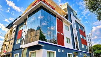 A multi-story hotel with a modern design, featuring large glass windows and a prominent red and blue facade.