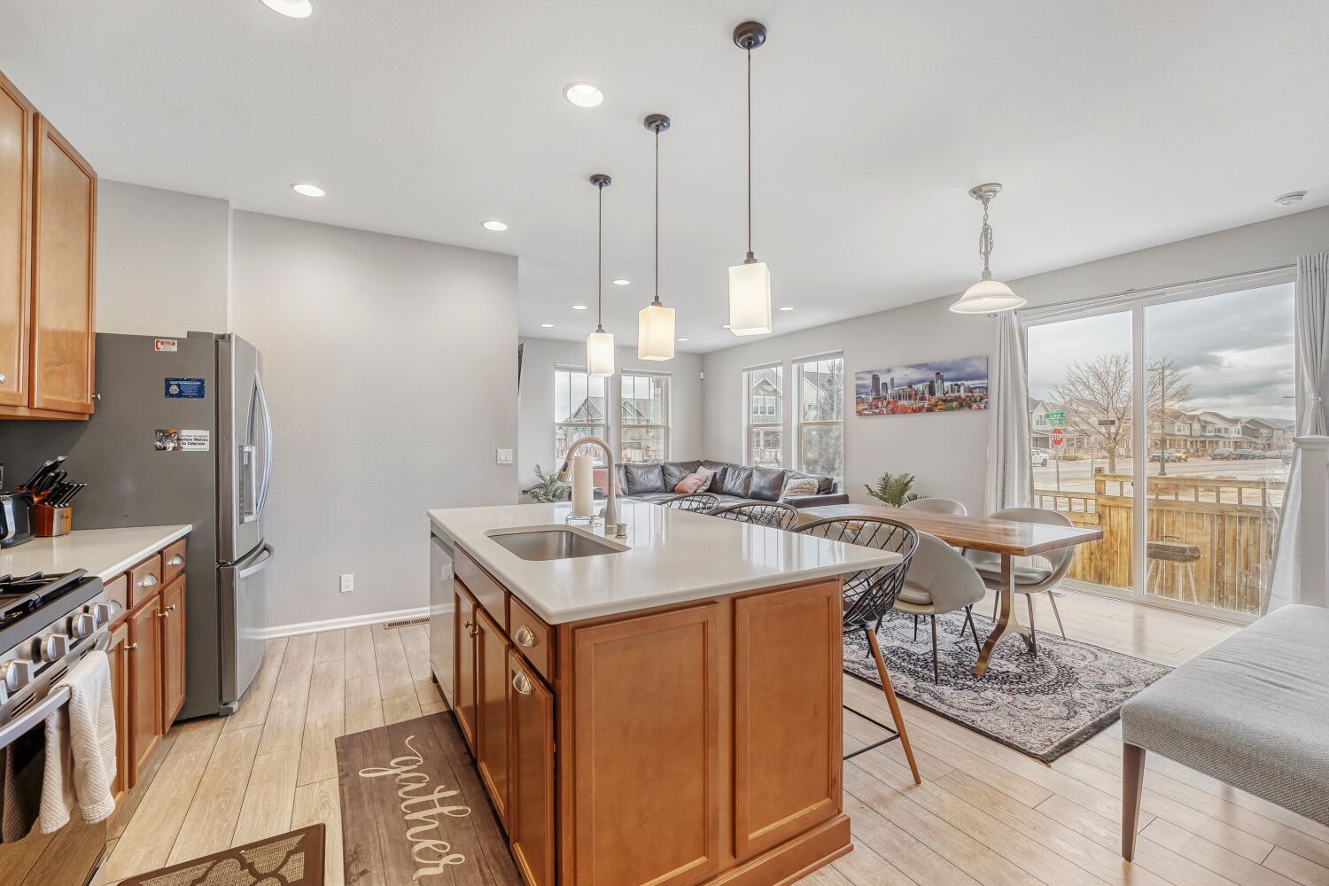 A modern kitchen with a central island, stainless steel appliances, and pendant lighting.