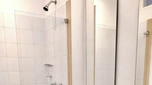Une salle de bain moderne avec des toilettes blanches, une douche et un lavabo.