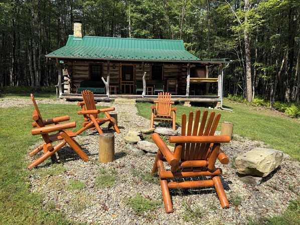 Une cabane dotée d’un toit végétalisé, d’une terrasse en bois et de plusieurs chaises Adirondack.