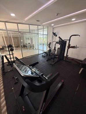 A gym with a treadmill, weight machines, and a mirror. - Welcome to MA Cartagena • Playa • Piscina (Bolívar)