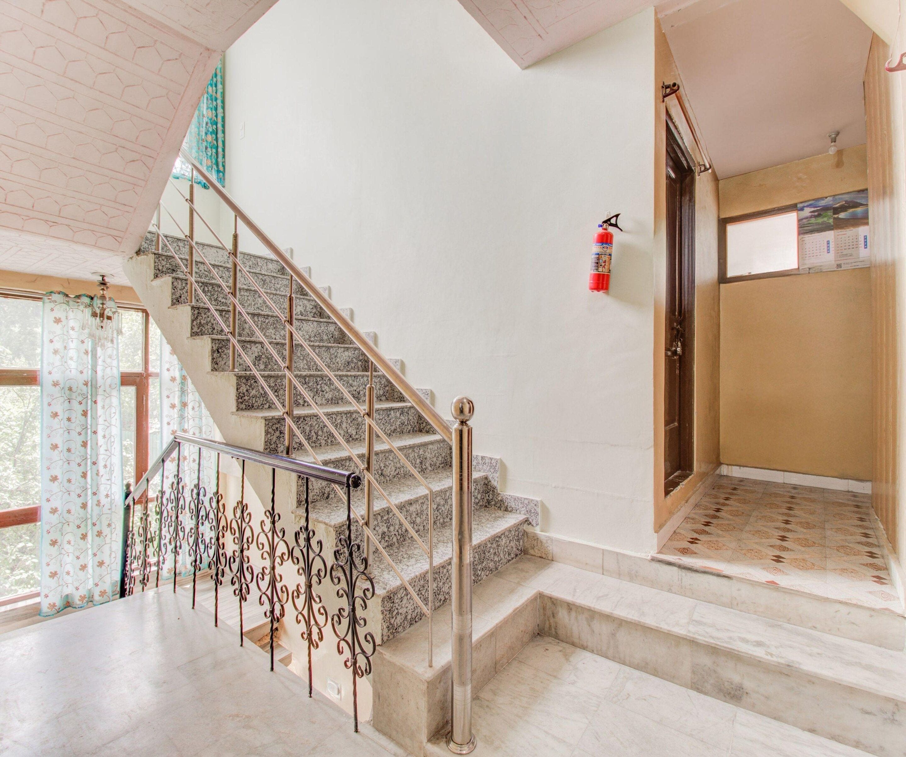 A staircase with metal railings and a fire extinguisher on the wall.