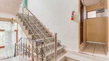 A staircase with metal railings and a fire extinguisher on the wall.