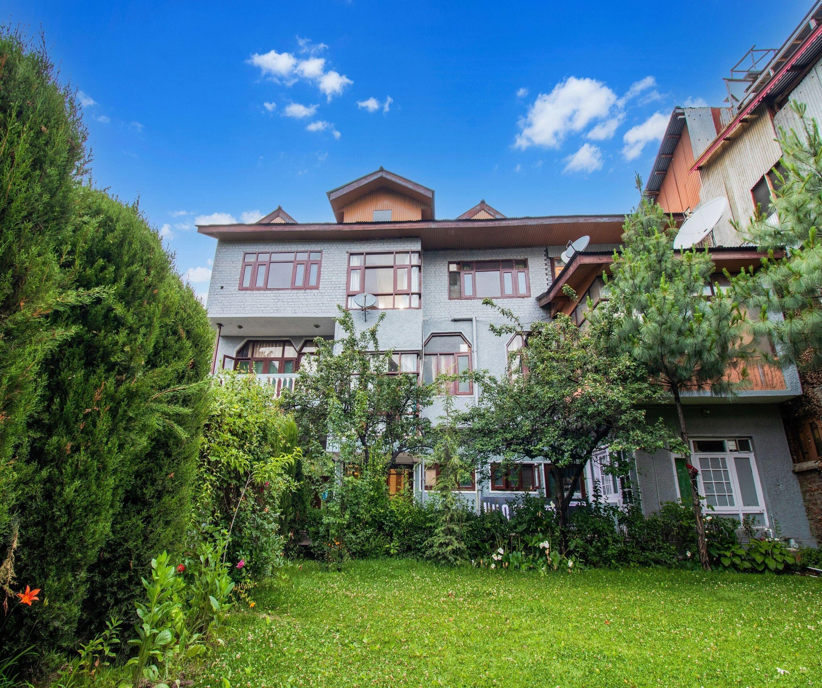 A two-story building with a traditional architectural style, featuring a balcony and satellite dishes.