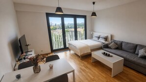 Una sala moderna con una cama, un sofá, una mesa de centro y un televisor.