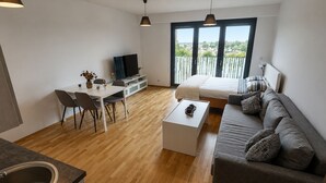 Un espacio habitable moderno con comedor, sofá y cama.