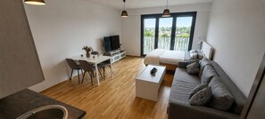 Um espaço moderno para viver com área de refeições, sofá e cama.