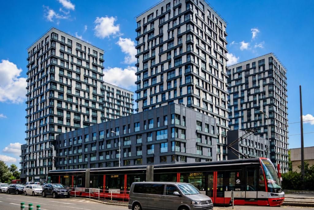 Un edificio moderno de gran altura con un tranvía en primer plano.