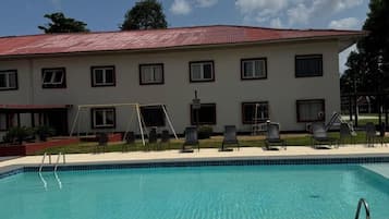 Uma área de piscina com um edifício ao fundo.