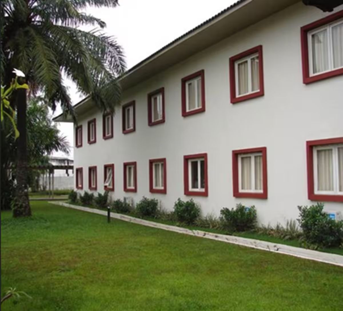 Um edifício com várias janelas e um gramado bem cuidado.