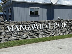 A stone wall with the text 'MANGAWHAI PARK' indicating a park or recreational area.