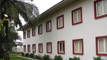 Um edifício com várias janelas e um gramado bem cuidado.