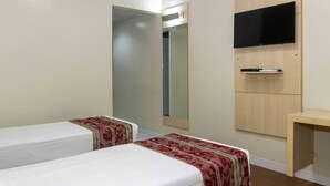 A hotel room with two single beds, a mirror, a TV mounted on the wall, and a small wooden desk. - Welcoming Room Perfect for Quick Weekend Escape Near Parque da Cidade - 1.3 mile (Pará)