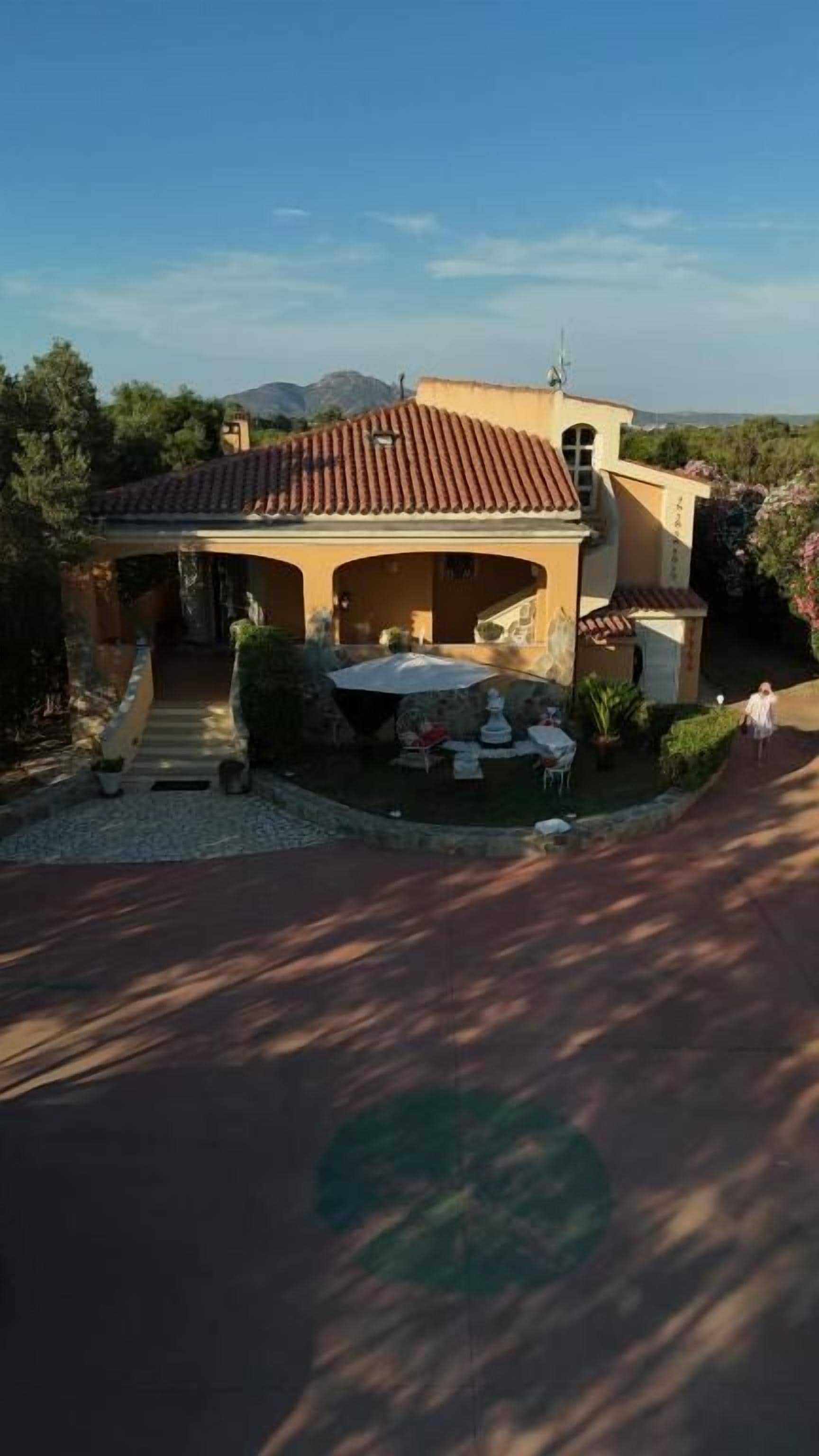 Una casa con patio, mobiliario exterior y vistas a las montañas.