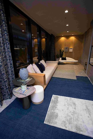 A modern living room with a sofa, a coffee table, and a rug.