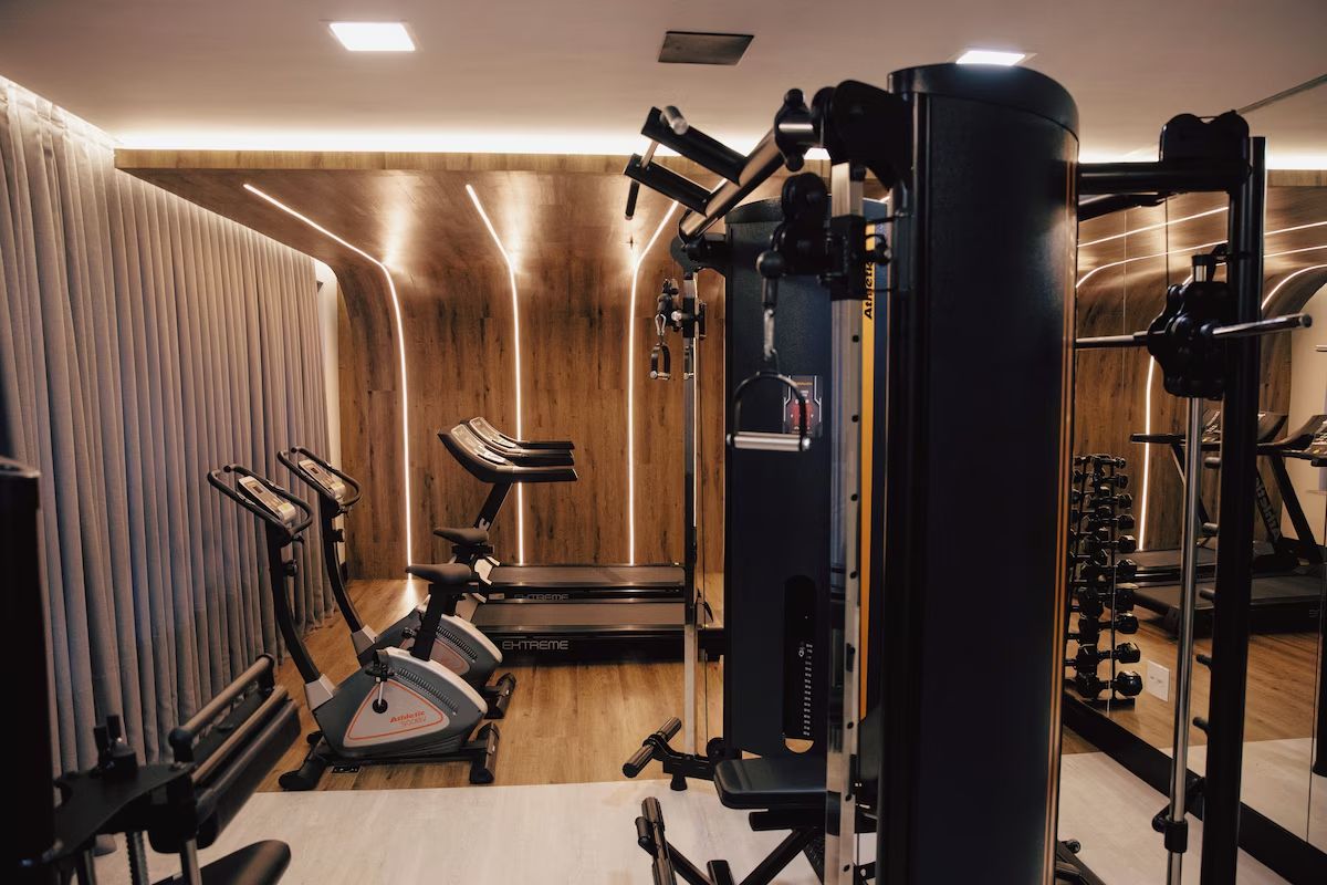 Une salle de sport équipée de machines de cardio, d’appareils de musculation et d’un tapis de course.