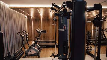 Une salle de sport équipée de machines de cardio, d’appareils de musculation et d’un tapis de course.