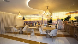 Ein modernes Restaurant mit runden Tischen und Stühlen, einer Stadtbild-Mural an der Wand und Blick auf die Stadtlandschaft.
