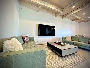 A modern living room with two sofas, a coffee table, and a flat-screen TV mounted on the wall. - Otaru Summer - Winter
Zeni House Coastal Stay (Zenibako)