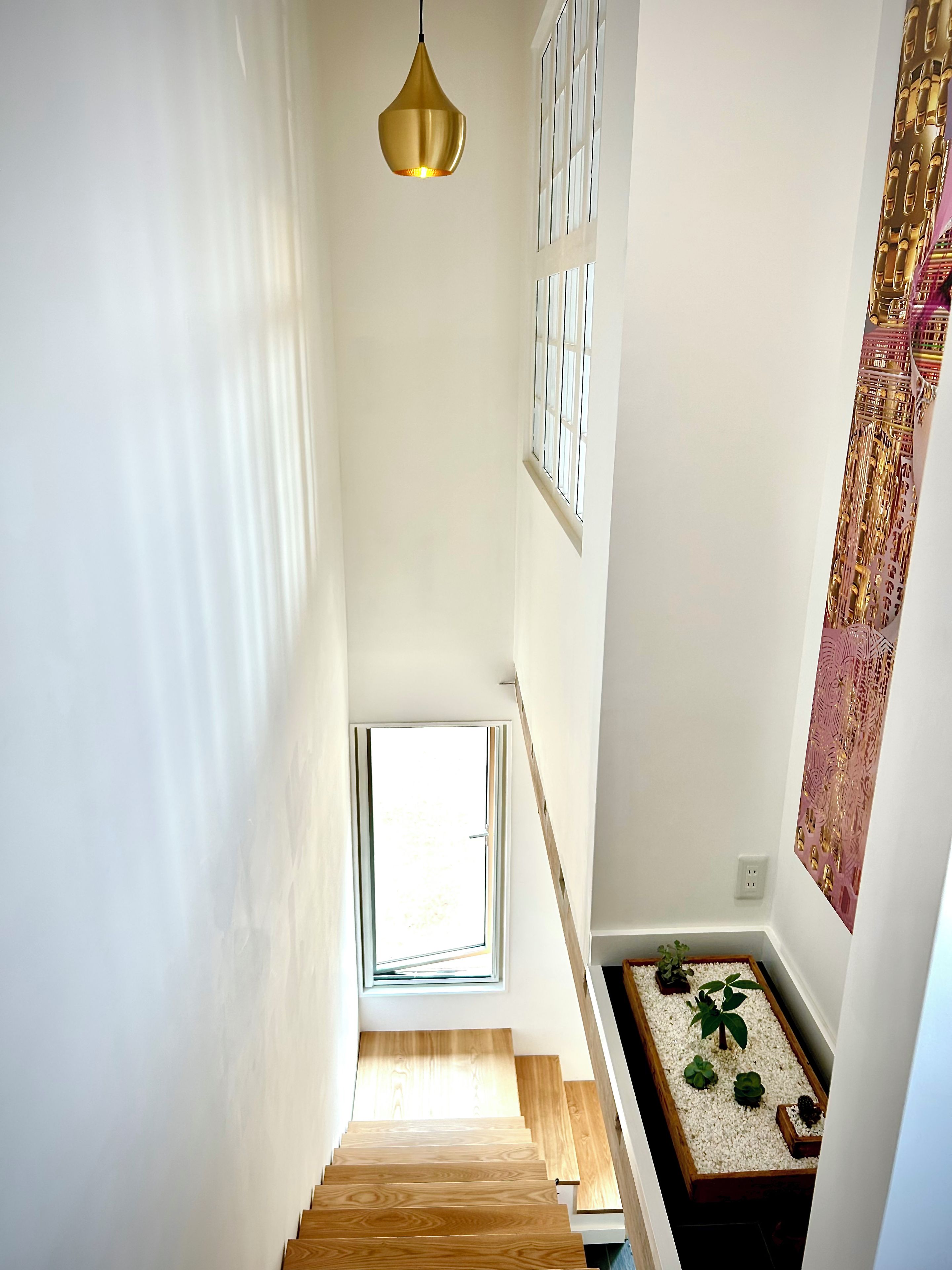 A staircase with wooden steps leading to a landing with a small window.