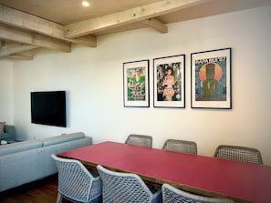 A conference room with a long table, wicker chairs, a flat-screen TV, and three framed posters on the wall. - Otaru Summer - Winter
Zeni House Coastal Stay (Zenibako)