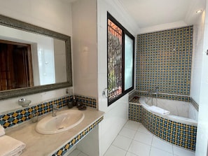 A bathroom with a sink, mirror, and bathtub. - Gite Nadia (Oulad Azzouz)