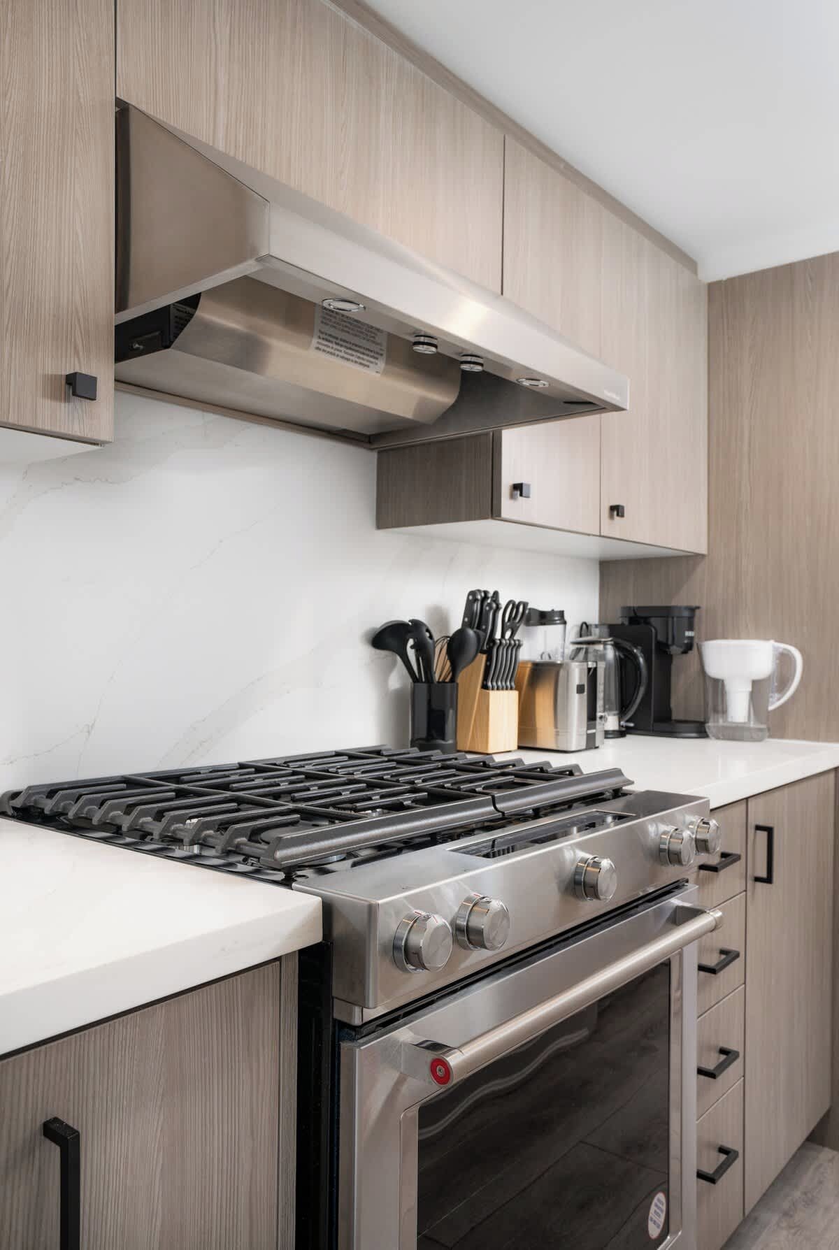 A modern kitchen with a stainless steel stove, oven, and a range hood.