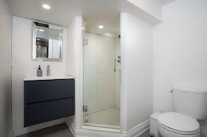 A bathroom with a white sink, mirror, and toilet. - Sun-Drenched West End Retreat | Walk to High Park (Toronto)