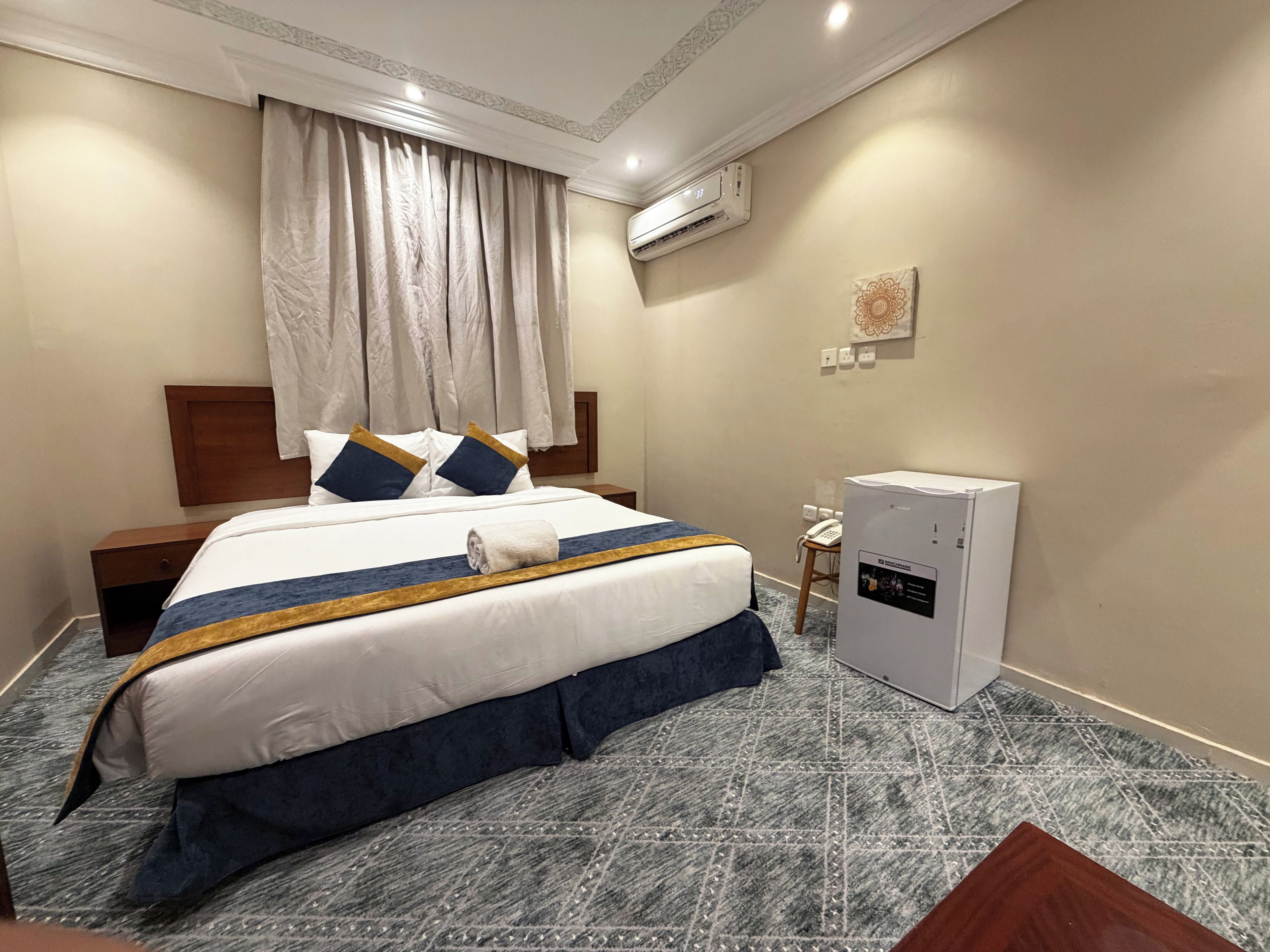 Une chambre d’hôtel équipée d’un lit, d’un bureau, d’un climatiseur et d’un téléphone.