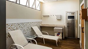 Una habitación con salpicadero de azulejos, una pequeña kitchenette, una puerta y una ventana.