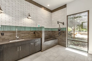 Un bagno moderno con schienale piastrellato, lavabo incassato e zona doccia.