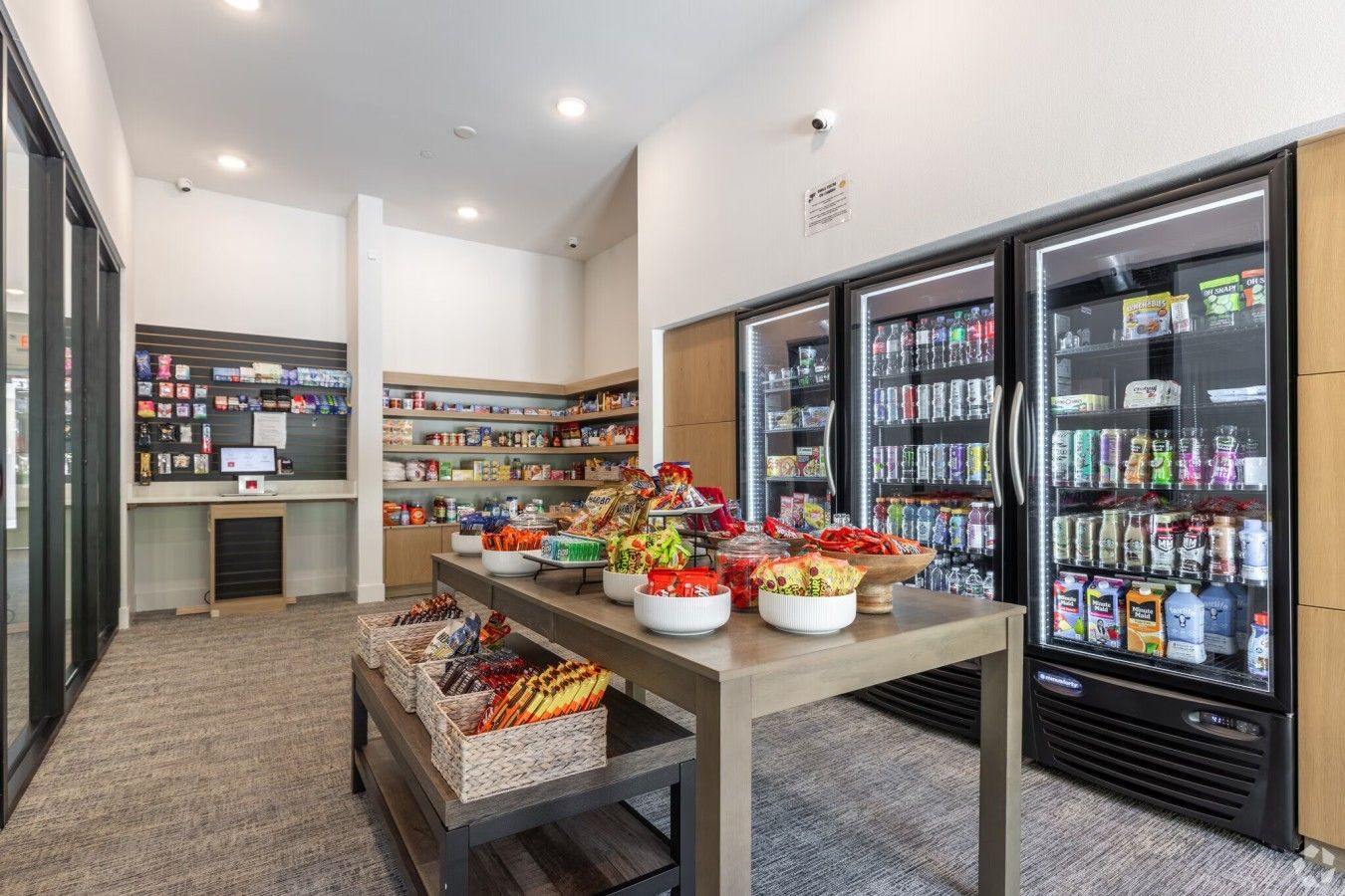 Un espace proposant des distributeurs automatiques où l’on peut se servir soi-même, avec un choix varié de collations et de boissons, un présentoir réfrigéré et un comptoir de caisse.