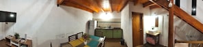 A narrow hallway with a dining area, kitchen, and a TV mounted on the wall. - Delightful 1-bedroom apartment with AC in Puerto Iguazú (Puerto Iguazú)