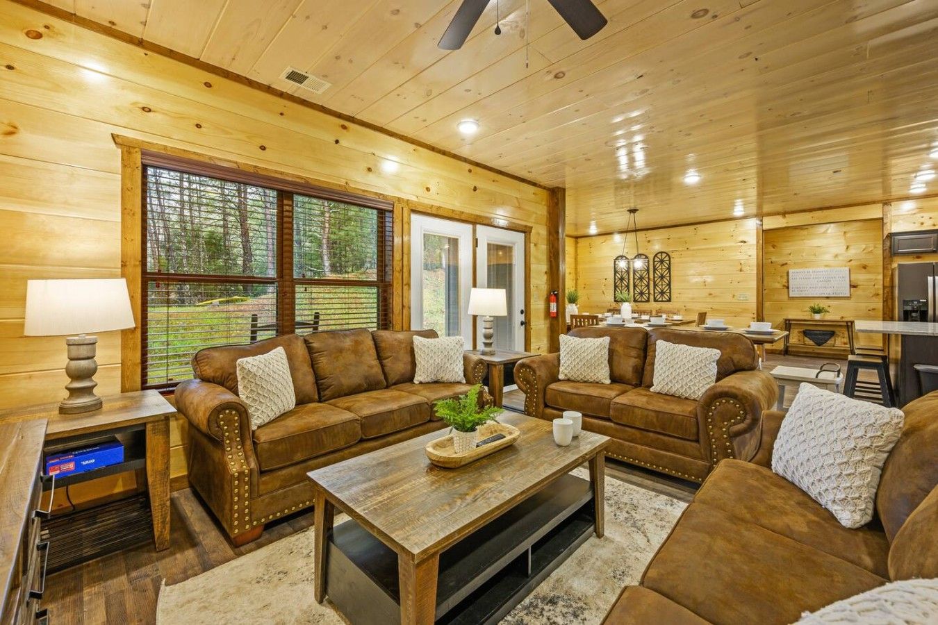 A cozy cabin interior with a living room, dining area, and kitchen.
