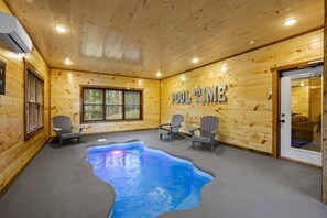 Un espace piscine avec des murs en bois, une piscine à l’eau bleutée et des fauteuils Adirondack.