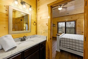 A wooden cabin interior with a bathroom featuring a sink, mirror, and towel. - 8BR*Sleeps 22*Pool*Game Room*Hot Tub*Mins to PF (Pigeon Forge)